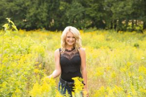 senior pictures in field of wildflowers